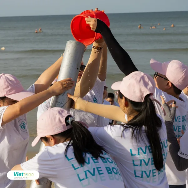 Thử thách đổ nước tiếp sức trên bãi biển — team building Paula's Choice với áo đồng phục Live Bold